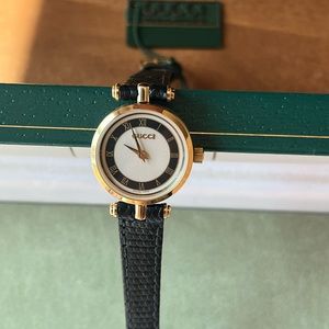 Gucci Model 2000L Women’s black & gold dial with black leather strap watch.